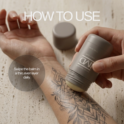 Applying IMD Daily Care Tattoo Balm to a healed tattoo — swipe a thin, even layer onto the skin daily for lasting color and hydration