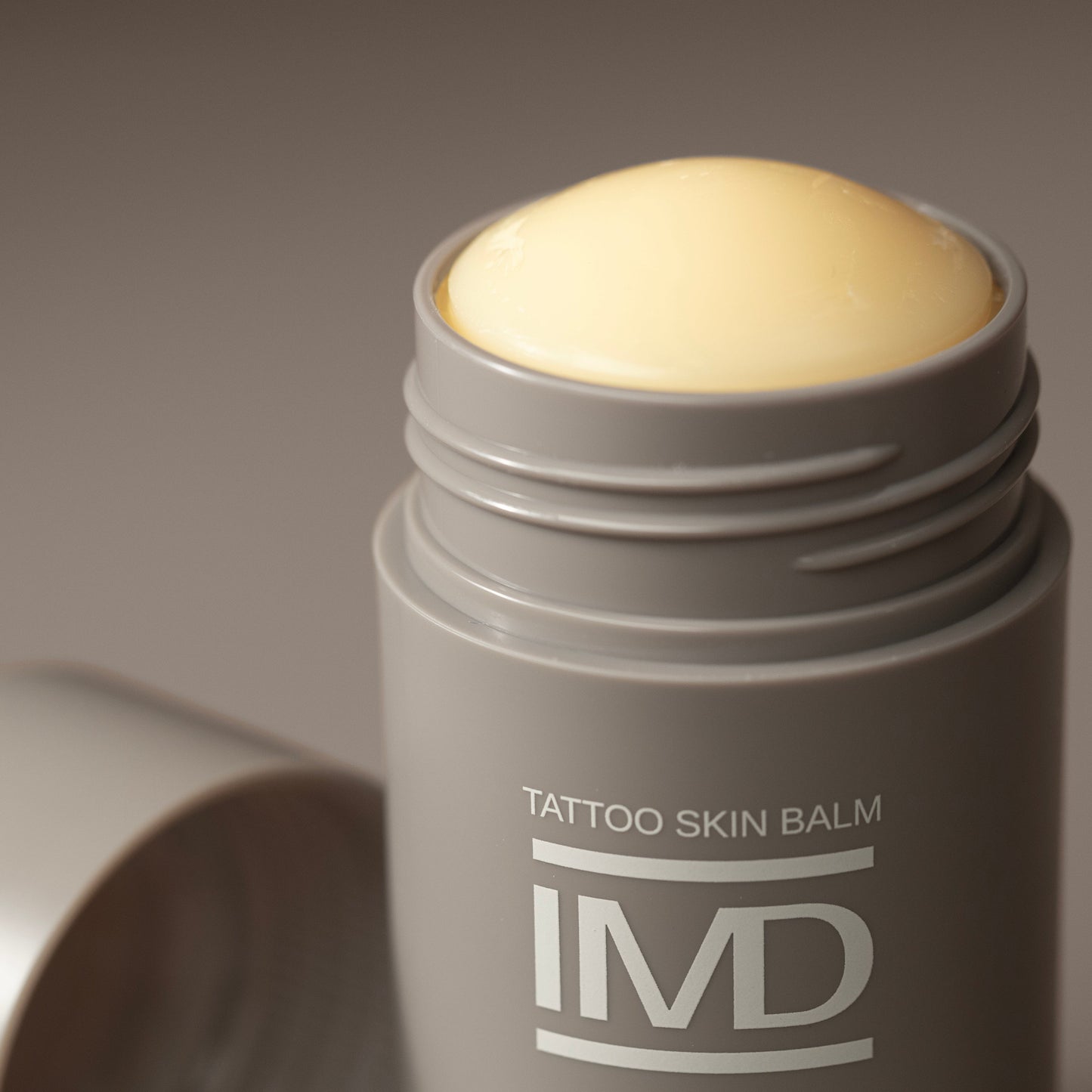 Close-up of IMD Daily Care Tattoo Skin Balm — plant-based, all-natural moisturizer for healed tattoos
