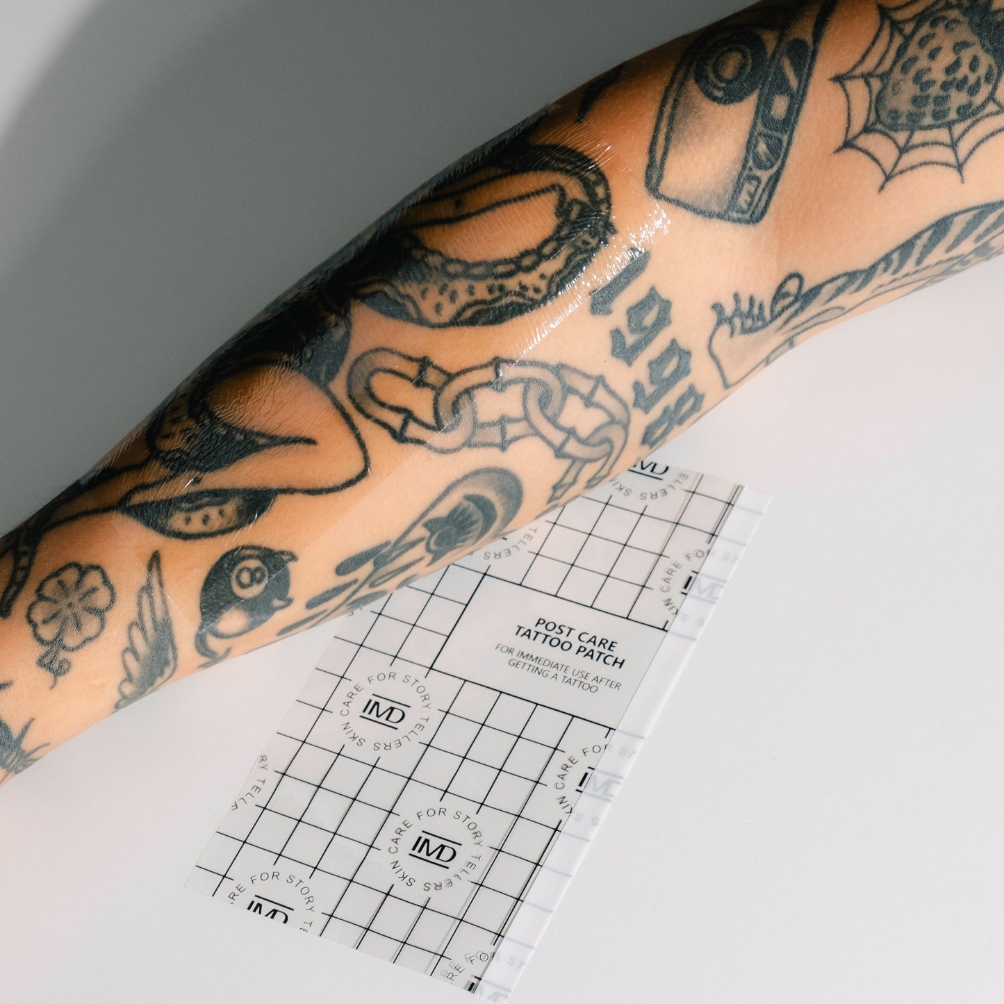 IMD Post Care Tattoo Patch applied to a tattooed forearm — dermatologist-approved waterproof wrap for new ink healing