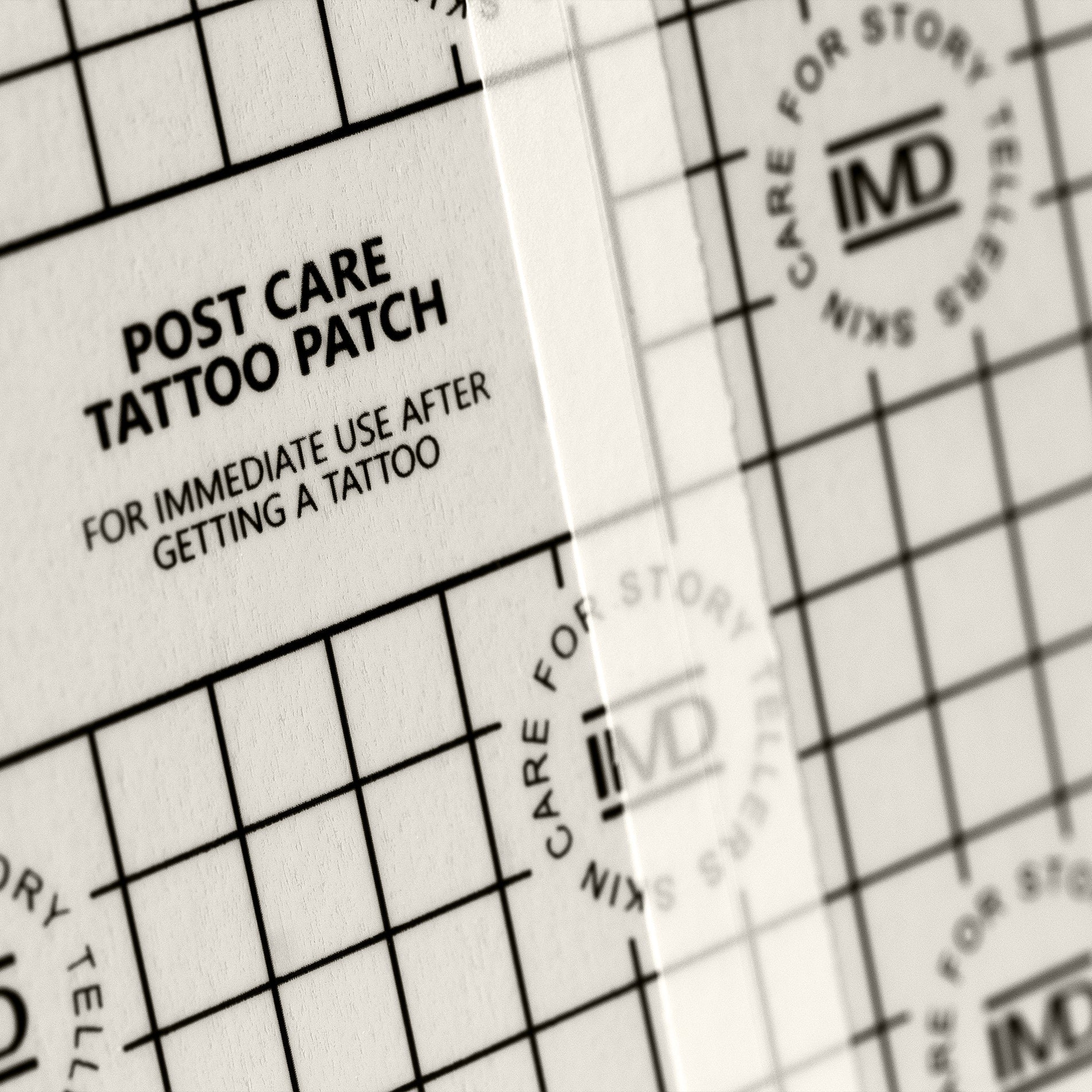 Close-up of IMD Post Care Tattoo Patch — waterproof, breathable film with grid texture for new tattoo aftercare